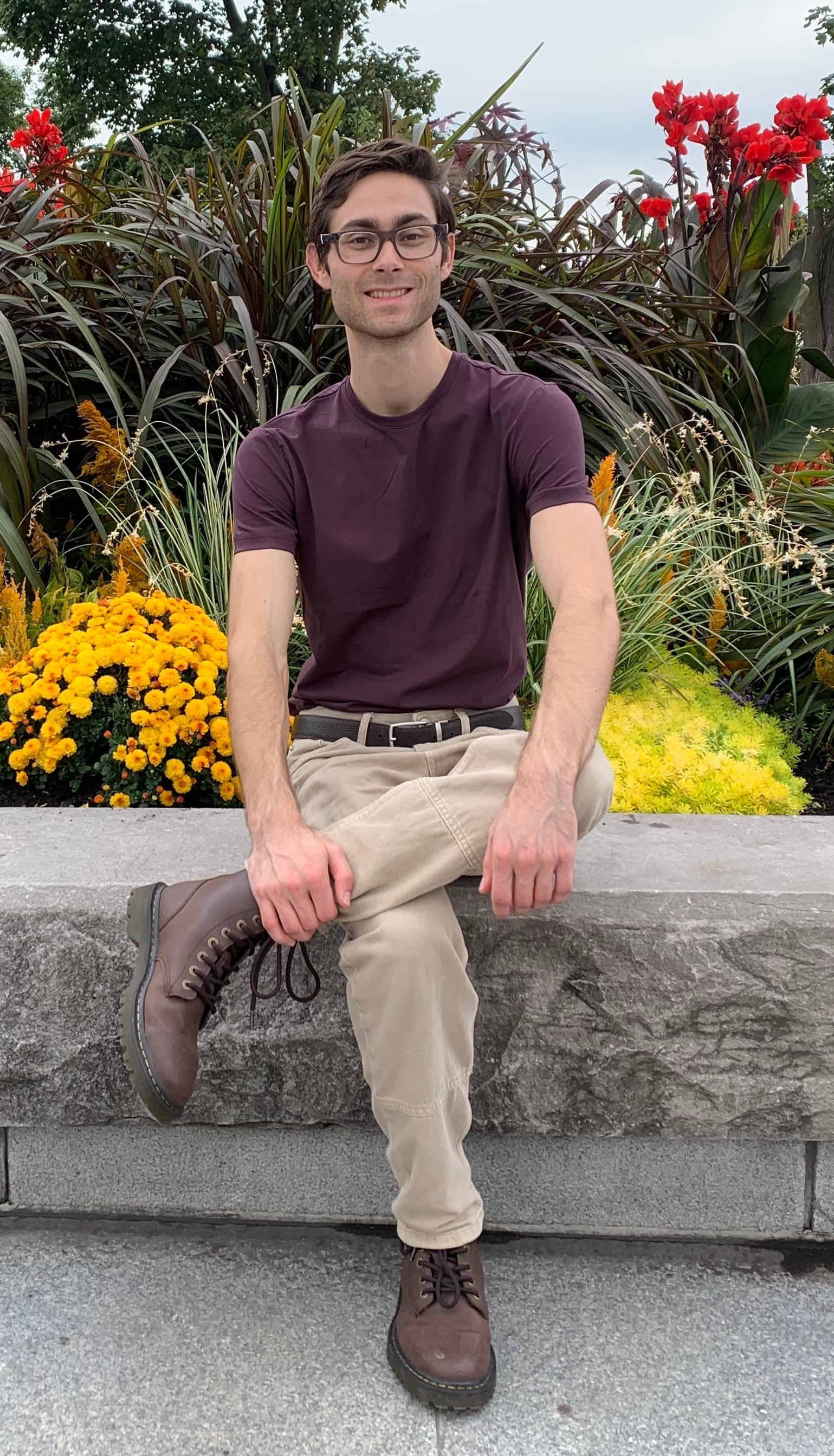 Picture of me in sitting near some flowers atop Mount Royal in Montreal
