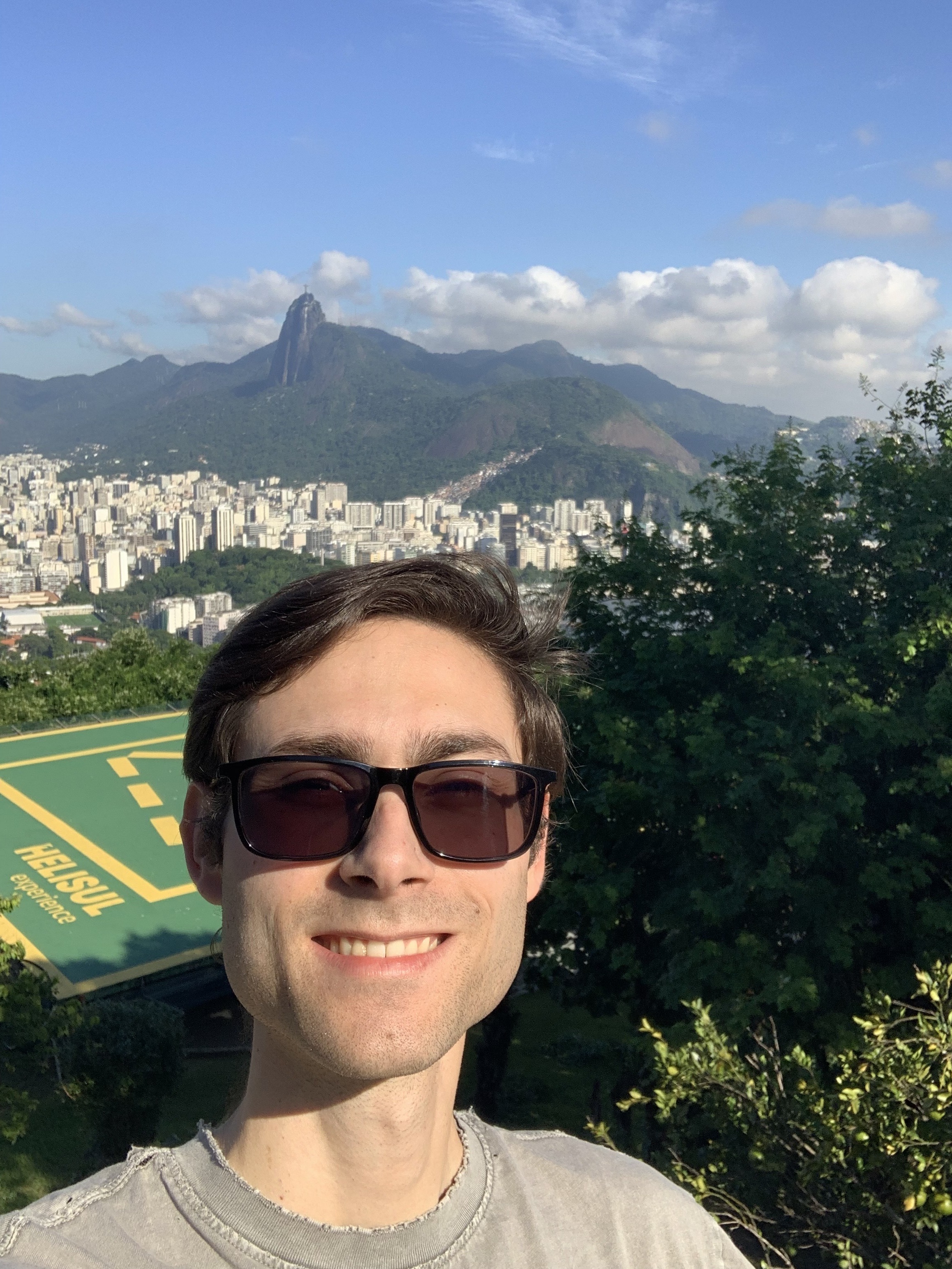 Me, smiling in front of the helipad atop Morra da Urca. Christ the Redeemer can just barely be seen in the top-left corner, behind me.